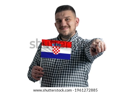 White guy holding a flag of Croatia and points forward in front of him isolated on a white background.