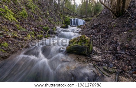 Blurred abstract background of running water, slow flow of water in a mountain river