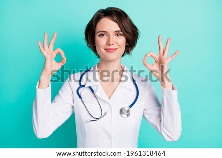 Photo of young woman happy positive smile doctor therapist show okey cool sign isolated over teal color background