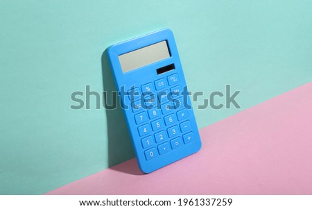 Calculator on blue-pink background. Minimalism. Trendy shadow. Creative layout