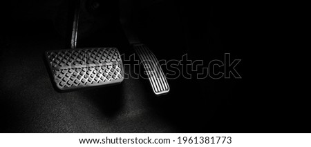 Close up the foot pressing foot pedal of a car to drive. Accelerator and brake pedal in a car. Driver driving the car by pushing accelerator and break pedals of the car. inside vehicle. control pedal. Royalty-Free Stock Photo #1961381773