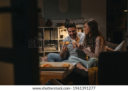 couple eating pizza at home Royalty-Free Stock Photo #1961391277