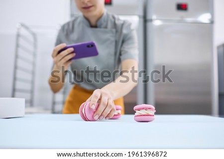 Young girl takes pictures of bright macaroons