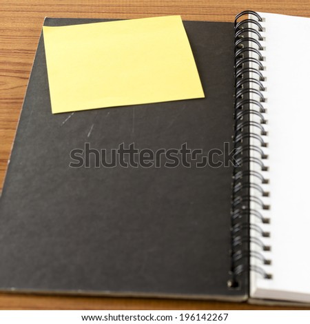 open notebook with post it on wood background