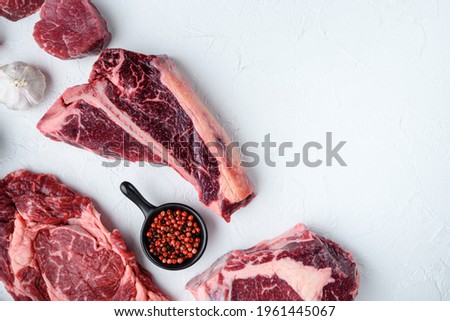 Various cuts of marbled beef meat and dry aged steaks set, tomahawk, t bone, club steak, rib eye and tenderloin cuts, on white stone background, top view flat lay, with copy space for text Royalty-Free Stock Photo #1961445067