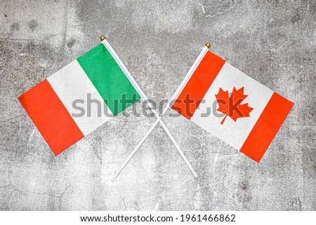Hand flags of Italy and Canada on Abstract background