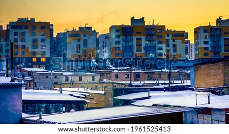 sunrise under many multi-storey buildings at winter time
