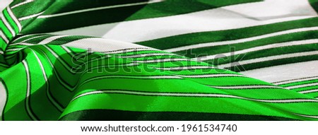 silk fabric with green and white striped pattern. Poncho with Mexican motives. texture, background