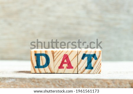 Alphabet letter block in word DAT (Abbreviation of Delivery at Terminal) on wood background
