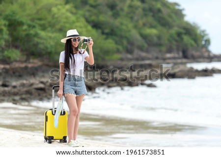 Happy traveler and tourism young women travel summer on  beach.  Asian smiling people holding yellow suitcase, map and camera take photo  and relax outdoor destination and leisure trip travel holiday