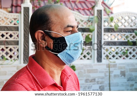 double mask prevent infection, mature indian man wearing two face mask to protect from new strain of coronavirus or new wave of covid-19 Omicron cases in India