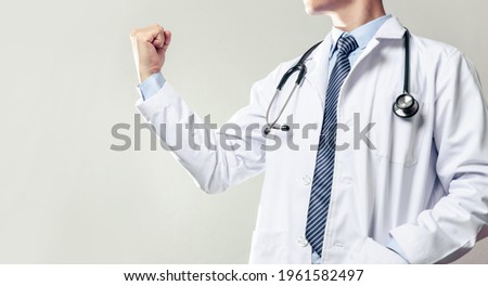 Doctor become to hero against illness such as coivd-19, doctor flexing his arm and showing his confidence. Royalty-Free Stock Photo #1961582497
