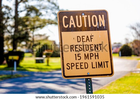Caution deaf resident 15 mph speed limit traffic road sign at a residential neighborhood. A considerate approach to support disabled people in the community while warning drivers for potential dangers