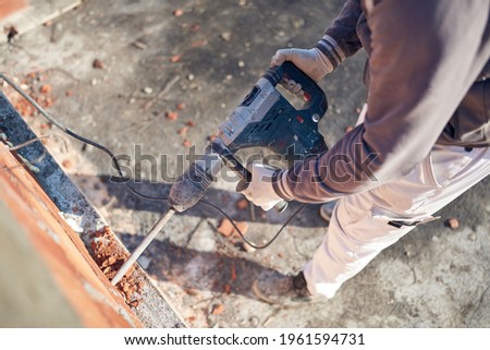 Real construction worker working on a house renovation - authentic person on the job. Royalty-Free Stock Photo #1961594731