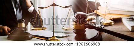Close up of hand lawyer working signing contract paper with wooden gavel judge in the office. lawyer and law ,judiciary and legislature courtroom legal concept.
