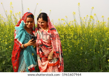 Indian rural ladies using phone in village Royalty-Free Stock Photo #1961607964