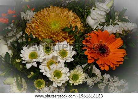 A close-up picture of a bouquet of funeral flowers. White, yellow and orange flowers