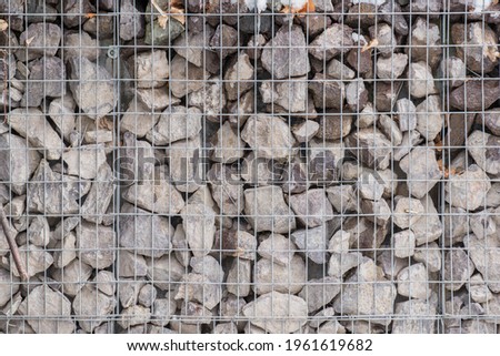 there are a lot of stones behind the metal bars