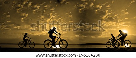 Image of sporty company friends on bicycles outdoors against sunset. Silhouette A lot phases of motion of four 4 cyclist along shoreline coast Reflection sun on water Copy Space for inscription