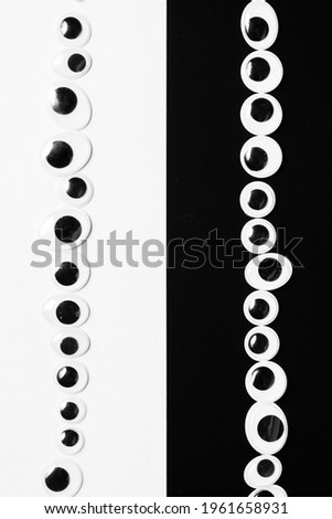 Toy eyes laid out on black and white hermetic background