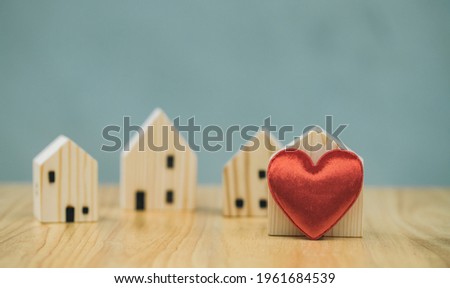 Photographs convey love and warmth within a family or community. A heart that represents love and a wooden house represents a strong community. Use for website or banner and articles. Love concept