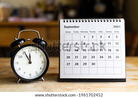 September 2021 calendar - month page showing date and vintage clock on wooden table Royalty-Free Stock Photo #1961702452