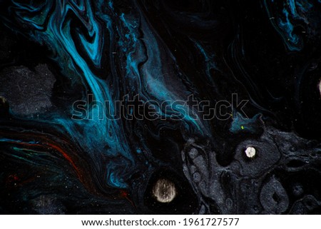 Texture in the style of fluid art. Abstract background with swirling paint effect. Liquid acrylic paint background. Black and blue colors.