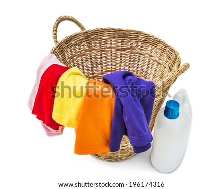Colorful clothes in a laundry wooden basket on white background