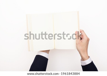 A book with blank pages opened by a businessman, for compositing