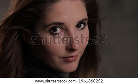 Young beautiful woman looks at the camera - photo shooting - studio photography