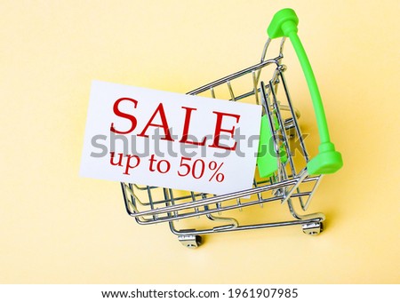 The card with the words SALE UP TO 50 OFF is in the shopping cart. Marketing concept