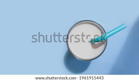  glass of milk, pipe on a colored background