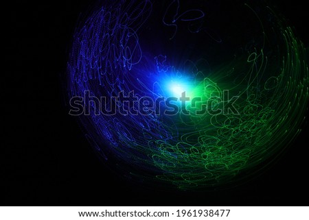 A group of colored flying lights forming a sphere on a black background. Light painting. Space galaxy.