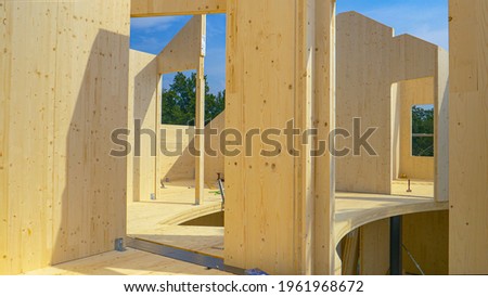 CLOSE UP: Beautiful hardwood real estate project is erected in the countryside. Glued-laminated timber house is being built in countryside. Aluminum ladders lie around the CLT house under construction Royalty-Free Stock Photo #1961968672
