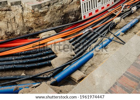 Repair of communications. Water supply, sewerage electrician. repair works. Excavated road in the city. Underground pipes and cables Royalty-Free Stock Photo #1961974447