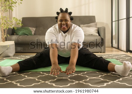 Woman showing exercises for her followers while sitting at the mat and smiling