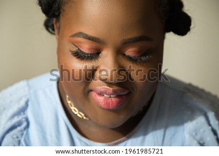 Female with vivid makeup looking down while posing in front of the camera
