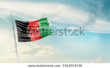 Afghanistan national flag waving in beautiful sky. Royalty-Free Stock Photo #1962054538