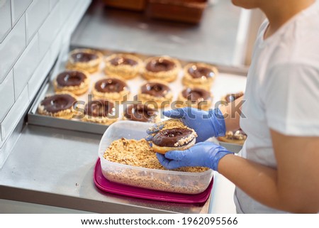 A worker making delicious donuts in a working atmosphere in a candy workshop. Pastry, dessert, sweet, making Royalty-Free Stock Photo #1962095566