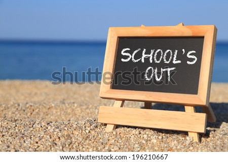 Blackboard with School's out text on the beach, Holiday sign