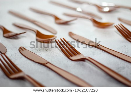 The brown recycled plastic spoon knife fork is placed on the white table.