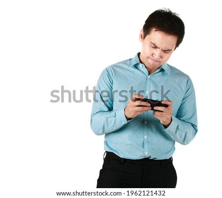 Asian man wearing shirt green holding hand smartphone playing social media internet and game Having a serious stress while using on the phone in white background. Concept Tense serious dissatisfied