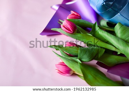 Flat lay style of color balloons with tulips floral decoration on pink background. Birthday, holiday or party concept, copy space for text.
