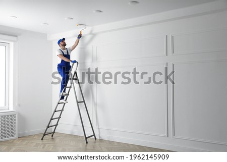 Handyman painting ceiling with white dye indoors, space for text Royalty-Free Stock Photo #1962145909