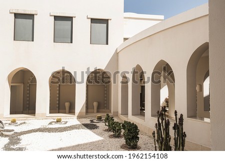 Modern east style building with beige walls, windows and sunlight shadows. Aesthetic abstract minimal architecture facade design