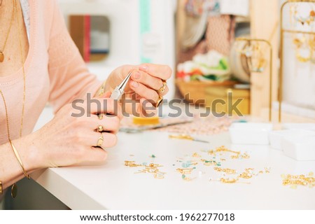 Close up image of female hands working with jewelry parts, woman making handcraft earrings
