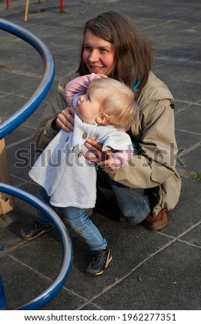 Mom with a little daughter on the playground