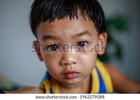 A Full Face of Adorable toddler Asian baby boy (2-year-old) Relaxing and Looking Camera in the Room with Blurry Background, Home Playing. Children's closeup portrait of activity and lifestyle concept.