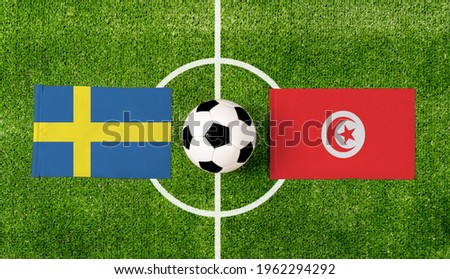 Top view ball with Sweden vs. Tunisia flags match on green football field.