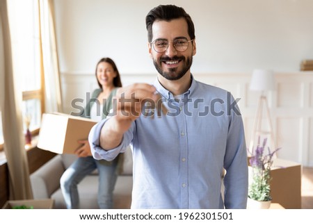 Portrait of smiling young man and woman family moving together to new house or apartment. Happy Caucasian husband show keys relocate to own home with wife. Relocation, rental concept. Royalty-Free Stock Photo #1962301501